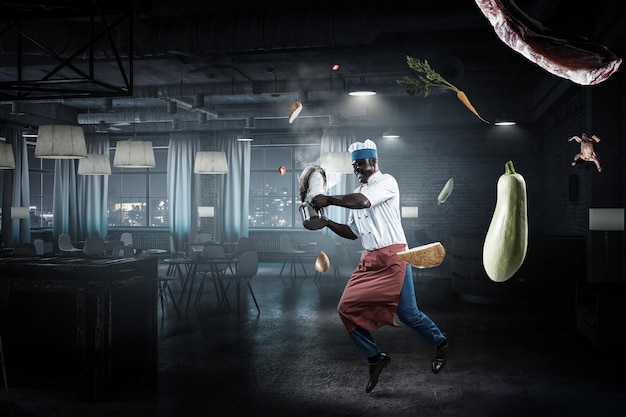 Un hombre negro alegre con un delantal y cocinando en acción. Técnica mixta