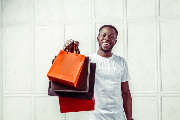 hombre negro con bolsas de compras