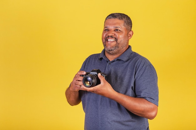 Hombre negro brasileño adulto con cámara de fotos fotógrafo aficionado a la fotografía