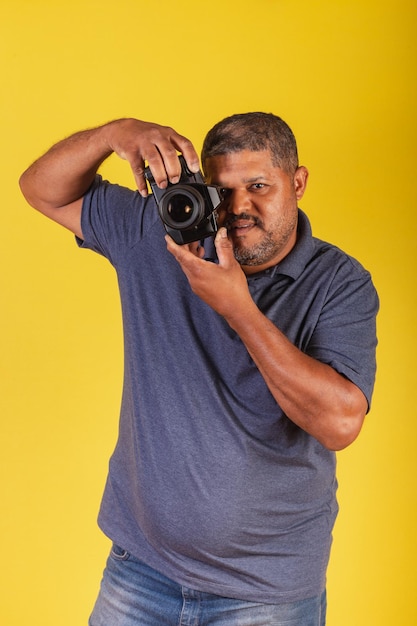 Hombre negro brasileño adulto con cámara de fotos fotógrafo aficionado a la fotografía