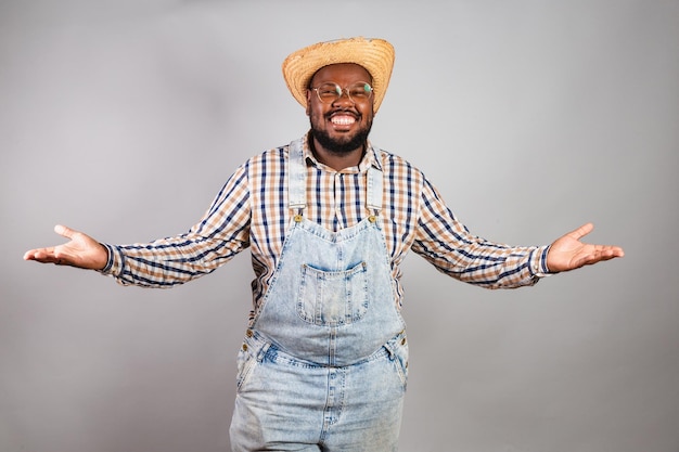 Hombre negro brasileño vestido con ropa de campo de festa junina festa de sao joao con los brazos abiertos bienvenidos