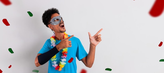 Foto hombre negro con disfraz de carnaval señalando aislado en blanco