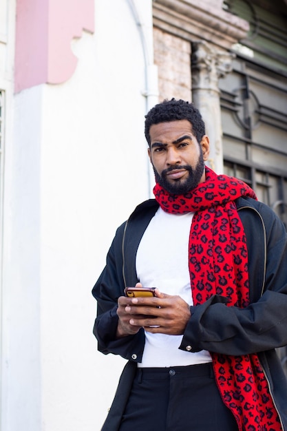 Foto hombre negro con estilo usando su teléfono inteligente