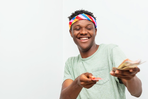 Hombre negro feliz con dinero y tarjeta de débito