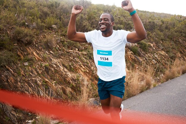 Hombre negro ganador de carrera y fitness con vítores atleta y deportes con carreras en la calle y competencia Ganancia de maratón y celebración con corredor africano feliz campeón y éxito al aire libre