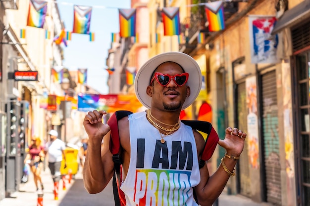 Un hombre negro gay en la fiesta del orgullo visitando la decoración de la bandera LGBT de la ciudad