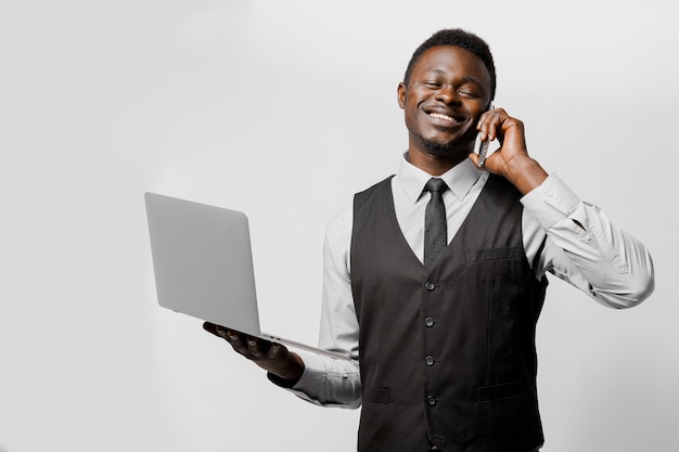 Hombre negro guapo habla por teléfono y sonríe