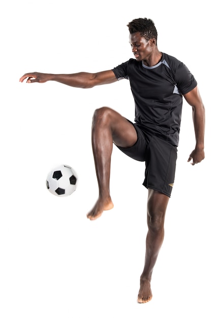 Foto hombre negro jugando al fútbol