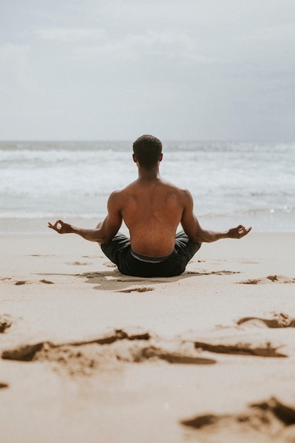 Hombre negro meditando en la playa