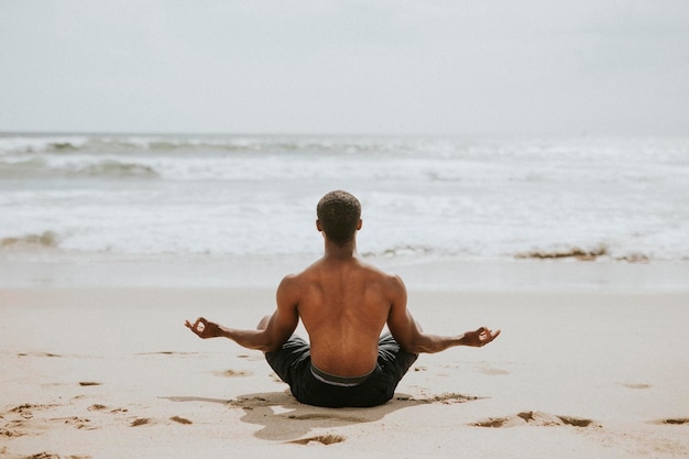 hombre negro, meditar, en la playa