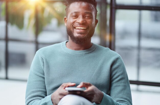 Hombre negro mirando el teléfono inteligente navegando por la tecnología de la oficina de Internet y la comunicación digital