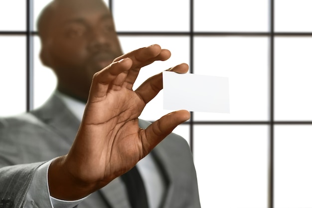 Hombre negro muestra tarjeta de visita.