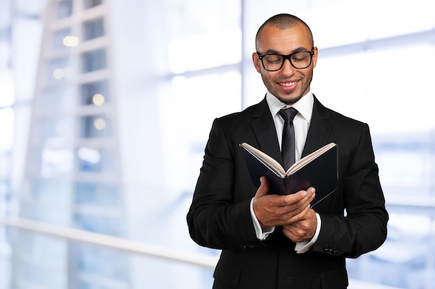 Hombre negro de negocios sosteniendo un libro