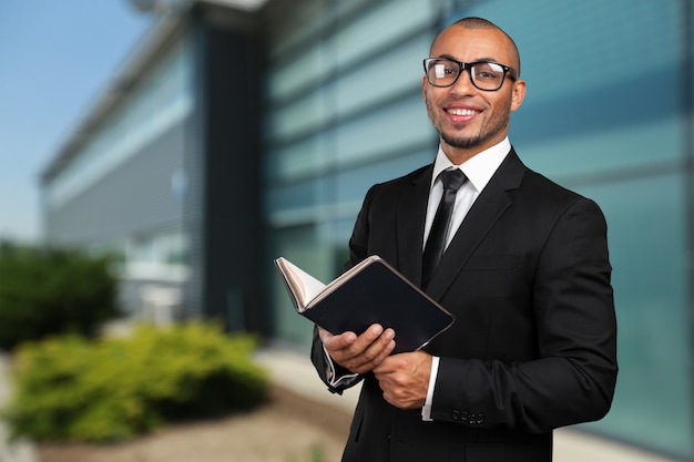 Hombre negro de negocios sosteniendo un libro