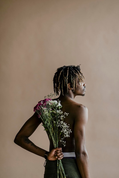 Hombre negro con un ramo de flores en la espalda