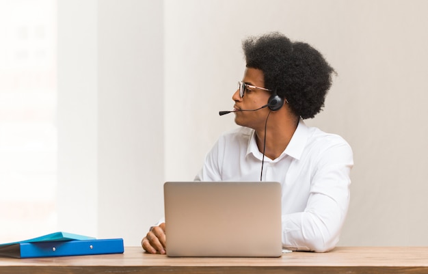 Hombre negro del telemarketer joven en el lado que mira al frente