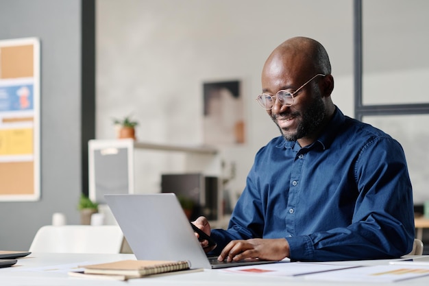 Hombre negro trabajando en una computadora en una oficina moderna
