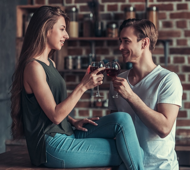 Hombre y niña con copas de vino tinto.