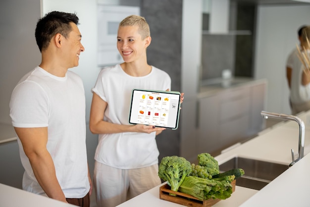 Hombre y niña muestran tienda de alimentos en línea en gadget