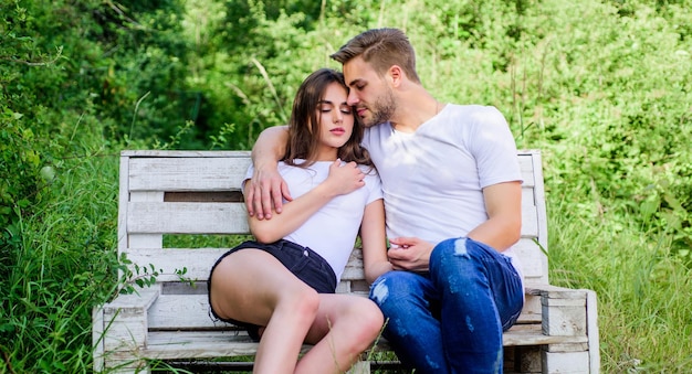 Hombre con niña en el parque. pareja enamorada. Moda casual. fin de semana rancho familiar. cita romántica. sé mi san valentín. campamento de verano en el bosque. pareja relajarse al aire libre en un banco. Concepto de unión.