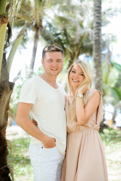 hombre y una niña posando cerca de palmeras