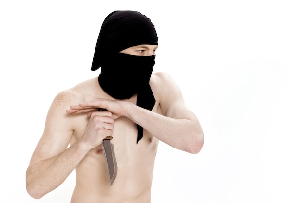 Hombre Ninja sostiene un cuchillo y está listo para atacar sobre fondo blanco.