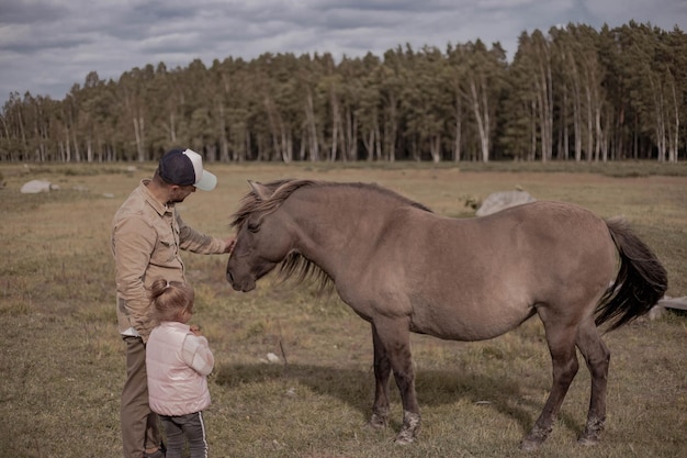 Hombre con niño durante la caminata conociendo un caballo