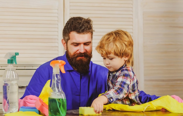 El hombre y el niño están desempolvando a papá e hijo limpiando la sala de estar juntos
