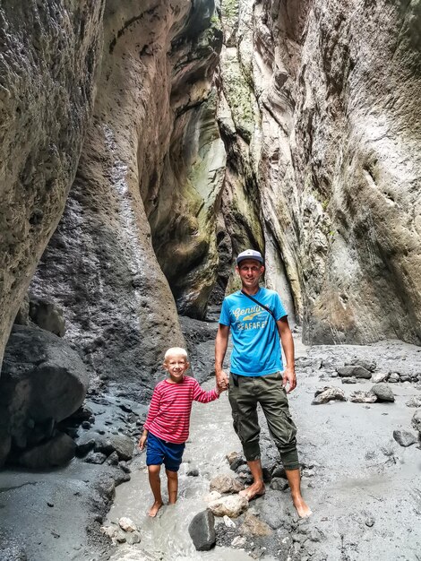 Un hombre con un niño en un estrecho desfiladero de montaña Karadakh bajo la luz del sol en Daguestán Rusia junio de 2021