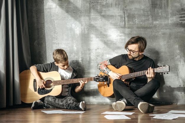 Hombre y un niño pequeño tocando guitarras