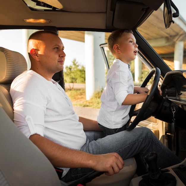 Hombre y niño de tiro medio en coche