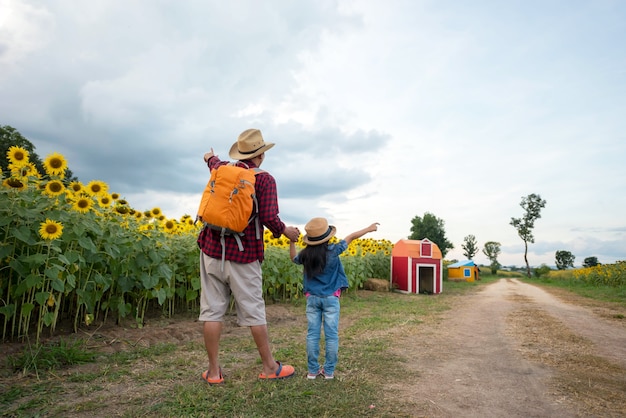 El hombre y el niño tomados de la mano en el jardín de girasol