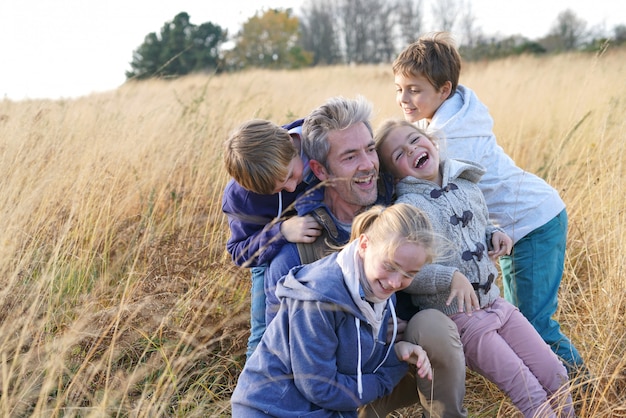 Foto hombre con niños jugando en el campo, en el campo