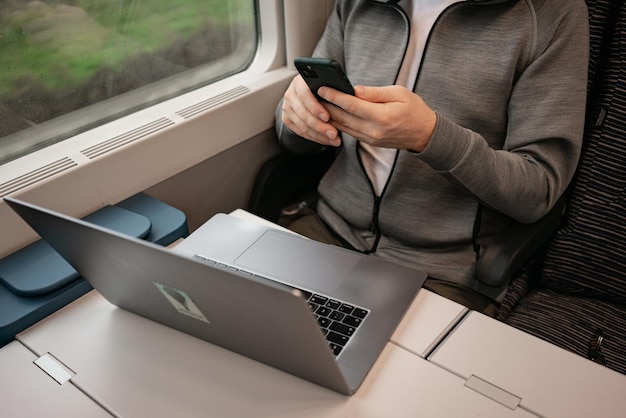 Un hombre no reconocido trabaja en el tren mientras viaja Trabajar en línea empleado remoto viaje en tren hombre de negocios en el camino Viaje en tren europeo