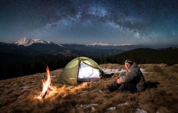 hombre de noche con fogata y carpa