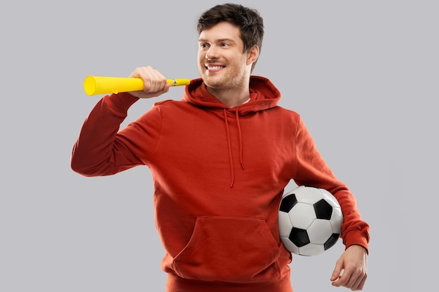 hombre o fanático de fútbol con pelota de fútbol y vuvuzela