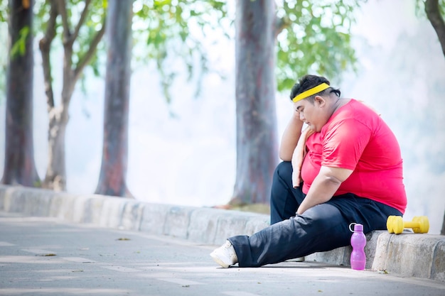 El hombre obeso joven se ve infeliz después del ejercicio