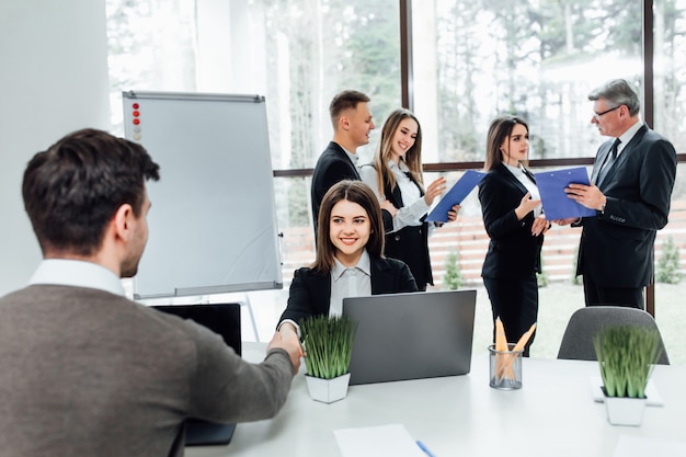 Hombre para ocultar nuevo gerente en el trabajo en la oficina