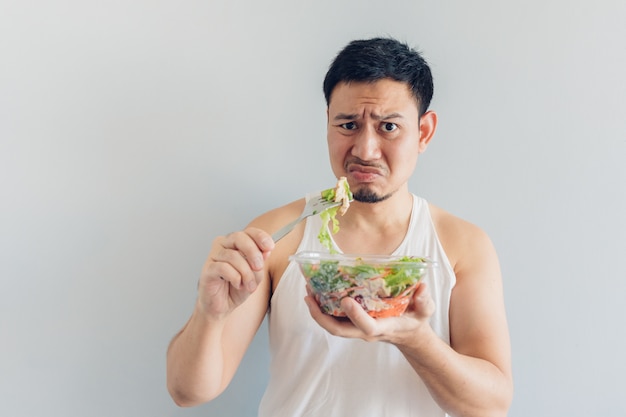 El hombre odia la comida sana de la ensalada.