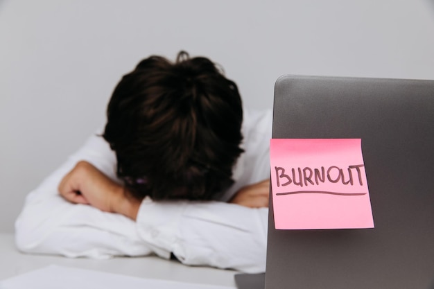 El hombre de la oficina duerme en su escritorio Concepto de síndrome de Burnout