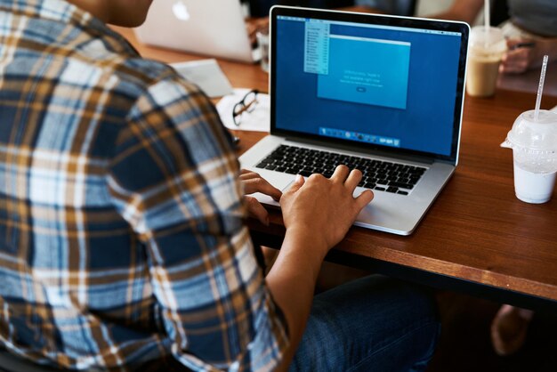 Hombre de oficina y espalda con información en la pantalla del portátil para la investigación y revisión del proyecto de TI del servidor Gente de la compañía y desarrollador con tecnología en la mesa para el plan de desarrollo de software y la actualización del sistema