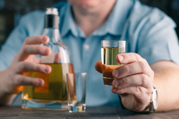 El hombre ofrece whisky. Hombre elegante guarda y sostiene un vaso