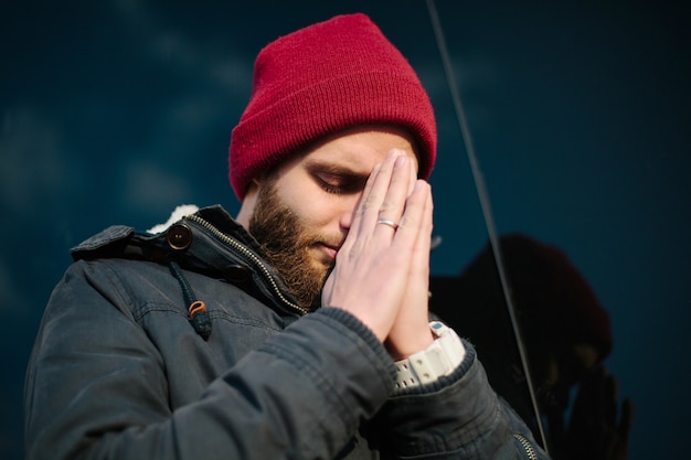 Hombre orando a Dios fuera vistiendo ropa de invierno