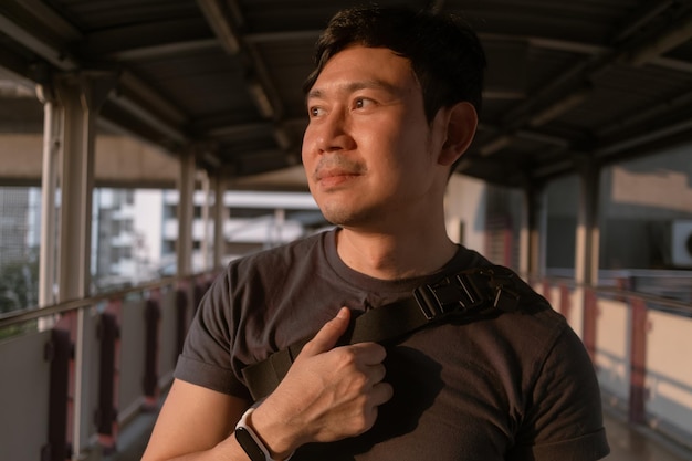 Foto hombre ordinario feliz caminando en la plataforma del tren aéreo en bangkok