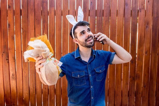 Hombre con orejas de conejo de Pascua hablando por teléfono