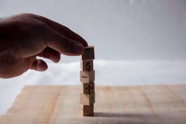 El hombre organiza los cubos de madera numéricos.