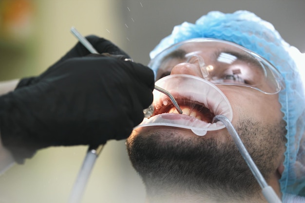 El hombre paciente en el tratamiento del dentista, de cerca