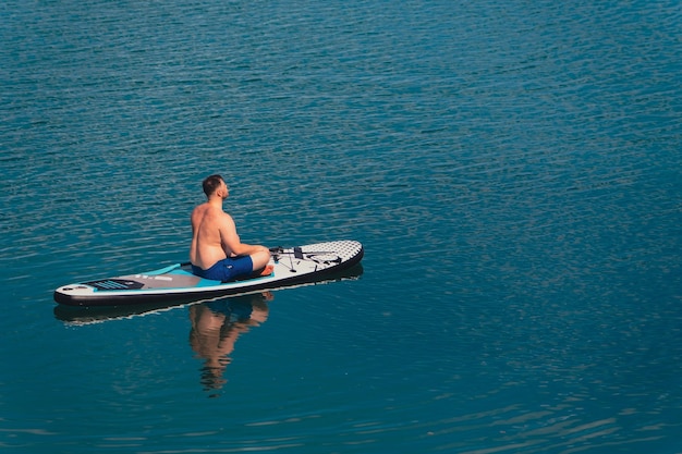 Hombre en paddleboard en medio del lago