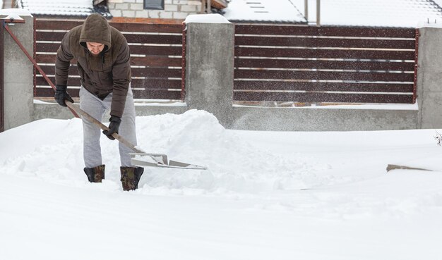 Hombre palear la nieve desde los escalones de su casa