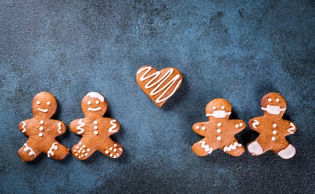 Hombre de pan de jengibre con mascarilla Hombre de pan de jengibre con mascarilla médica Quédate en casa concepto de coronavirus Navidad pandémica Pareja de galletas con máscara Año nuevo covid 19